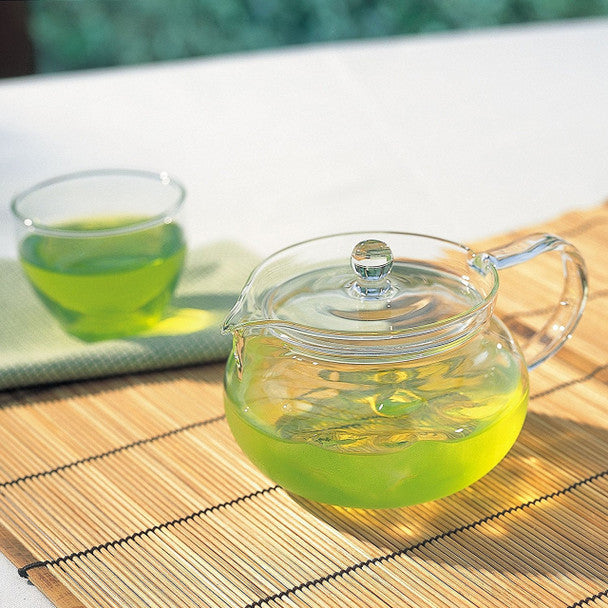 Hario Chacha glass teapot brewing green tea beside two glass cups