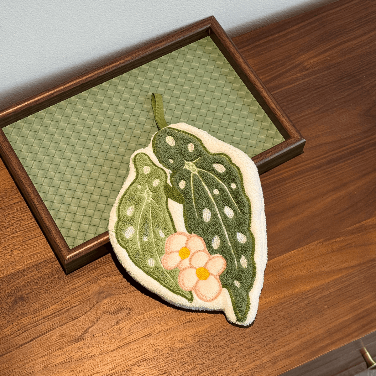 Close-up of the botanical leaf embroidery on the hanging hand towel.
