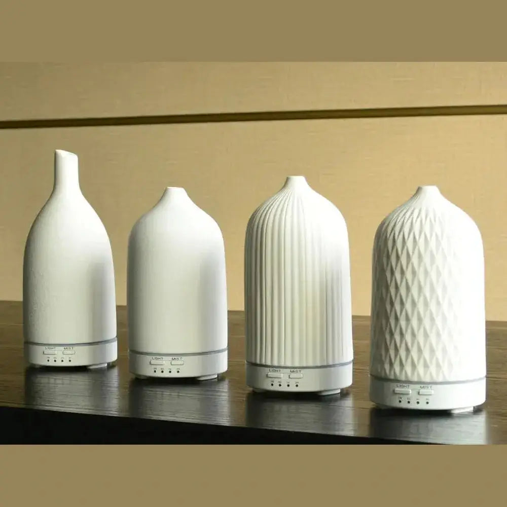 Four color-changing ceramic essential oil diffusers on display, showcasing unique designs for home ambiance.