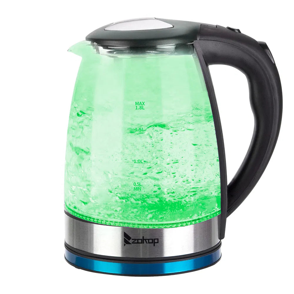 Glass electric kettle glowing green while heating