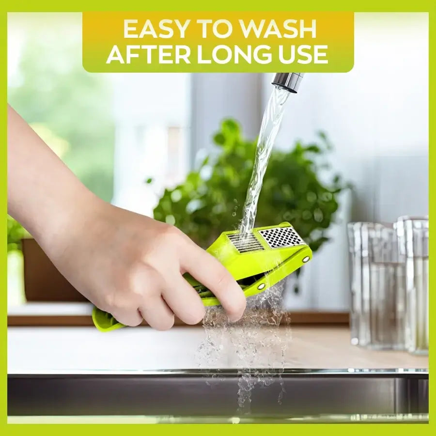 2-in-1 Garlic Press and Slicer, Green Options being washed under running water.