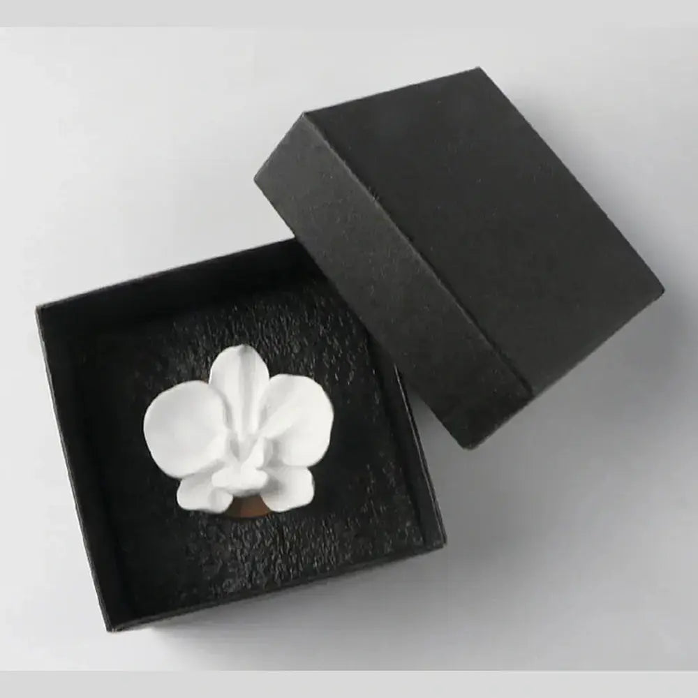 Flower aroma diffuser for home in black gift box with white orchid design.
