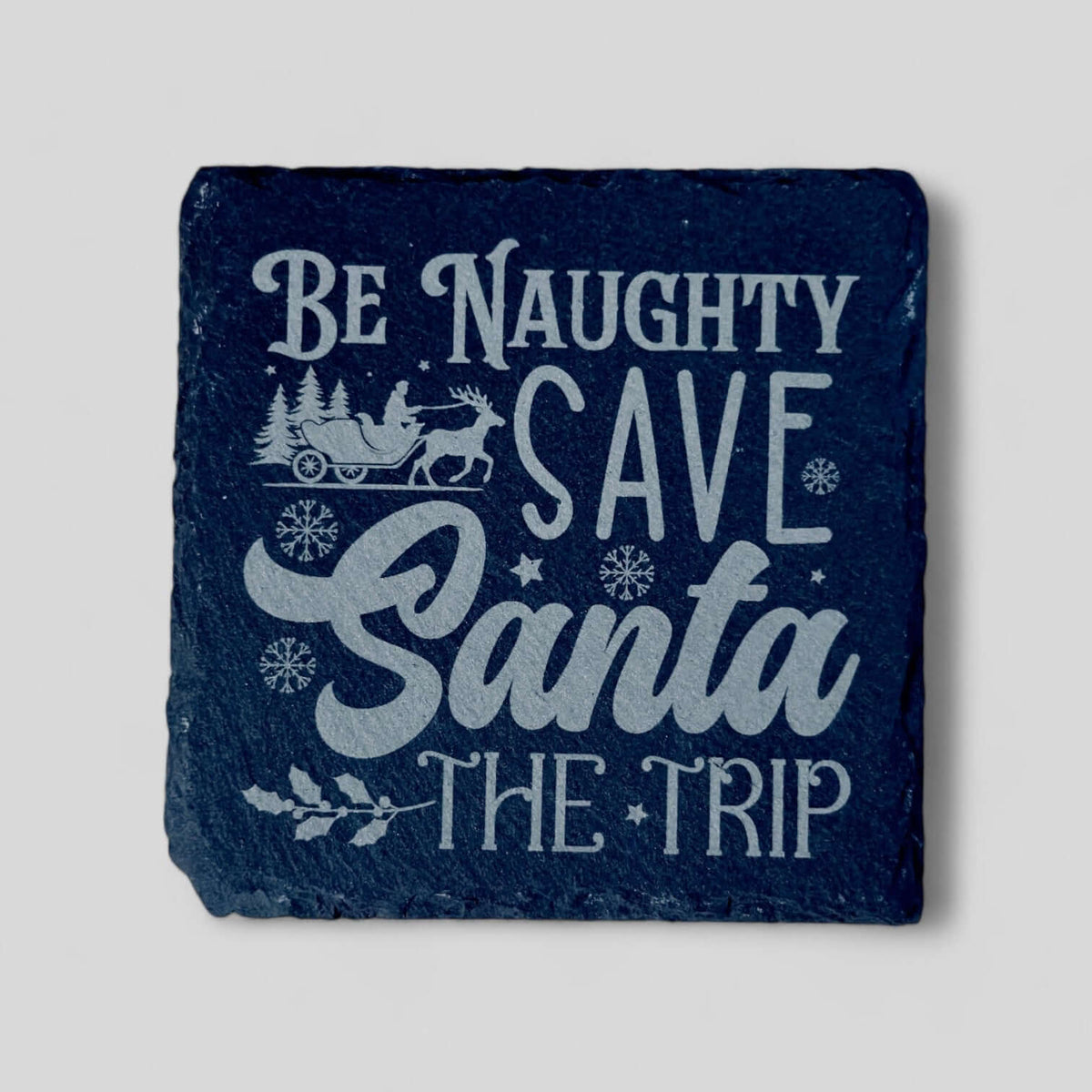Set of engraved "Be Naughty, Save Santa the Trip" Christmas slate coasters with non-slip backing.