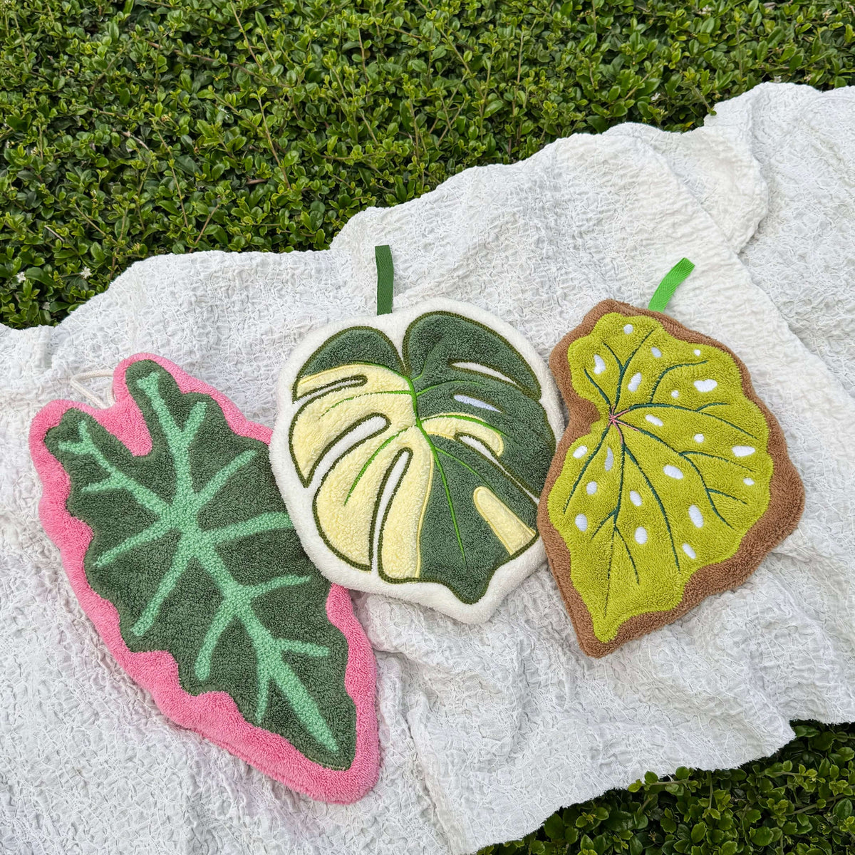 Hanging hand towel with botanical leaf design draped over an oven handle in the kitchen.