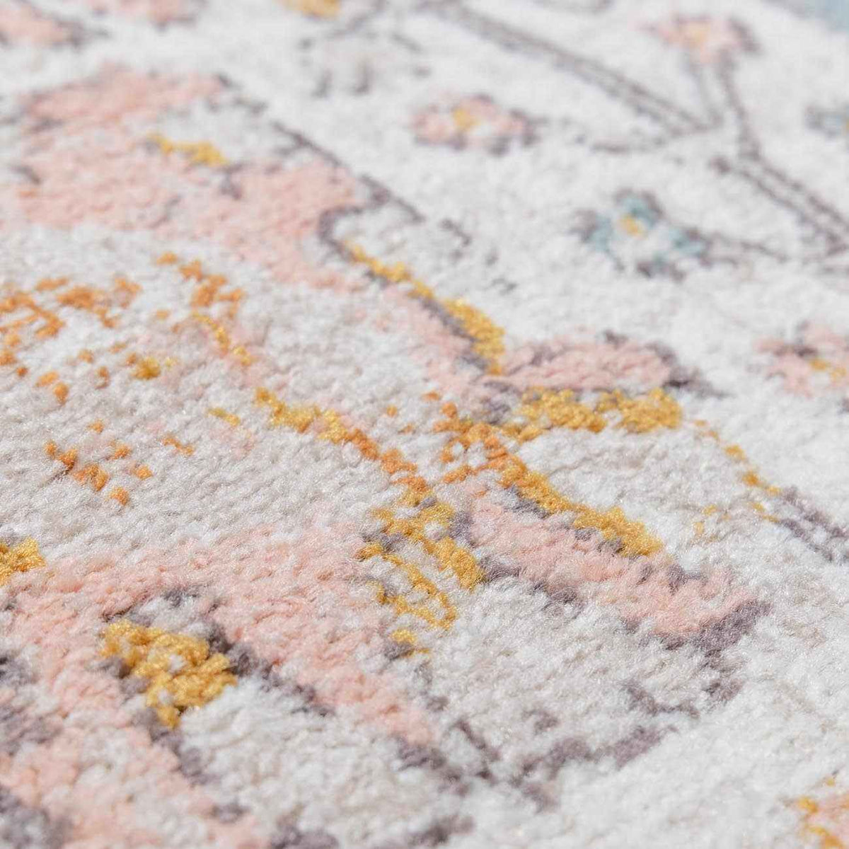 Close-up texture of an elegant area rug showcasing intricate patterns and soft pastel colors.