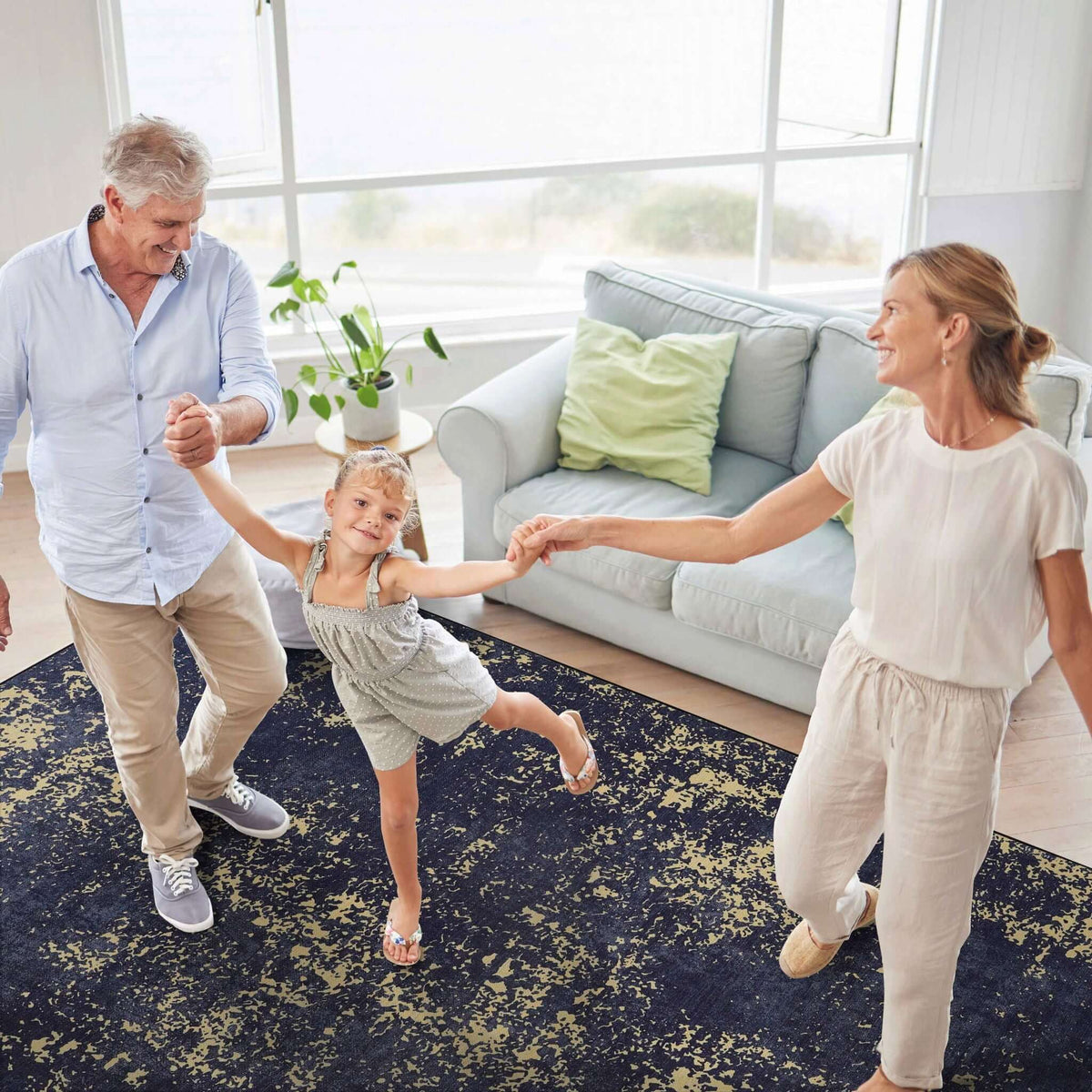 washable stain-resistant area rug with abstract design in dark blue and gold, family playing in living room