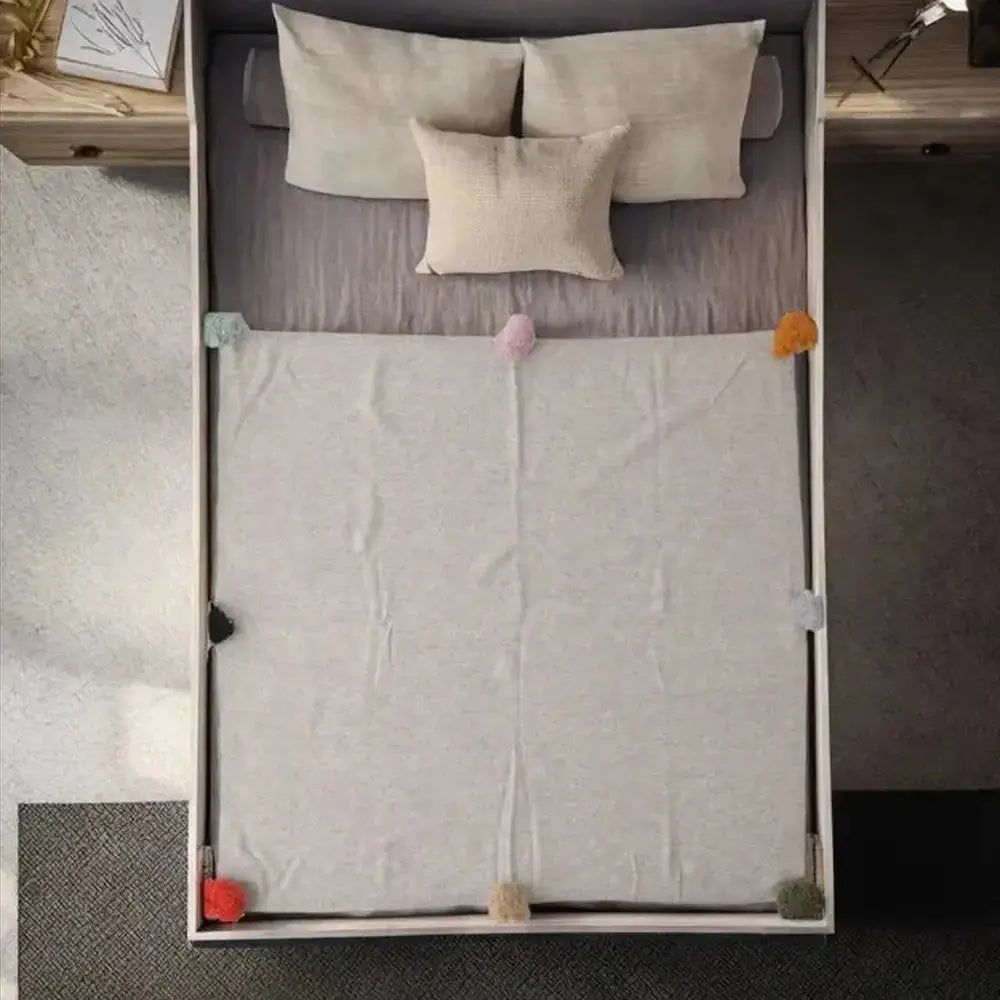 Luxury cashmere throw blanket elegantly draped on a bed.