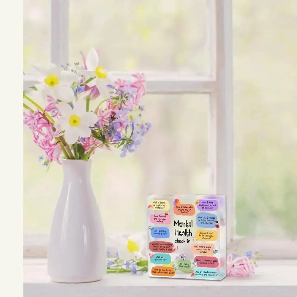 Self-Care Encouragement Sign on display with flowers in a window.