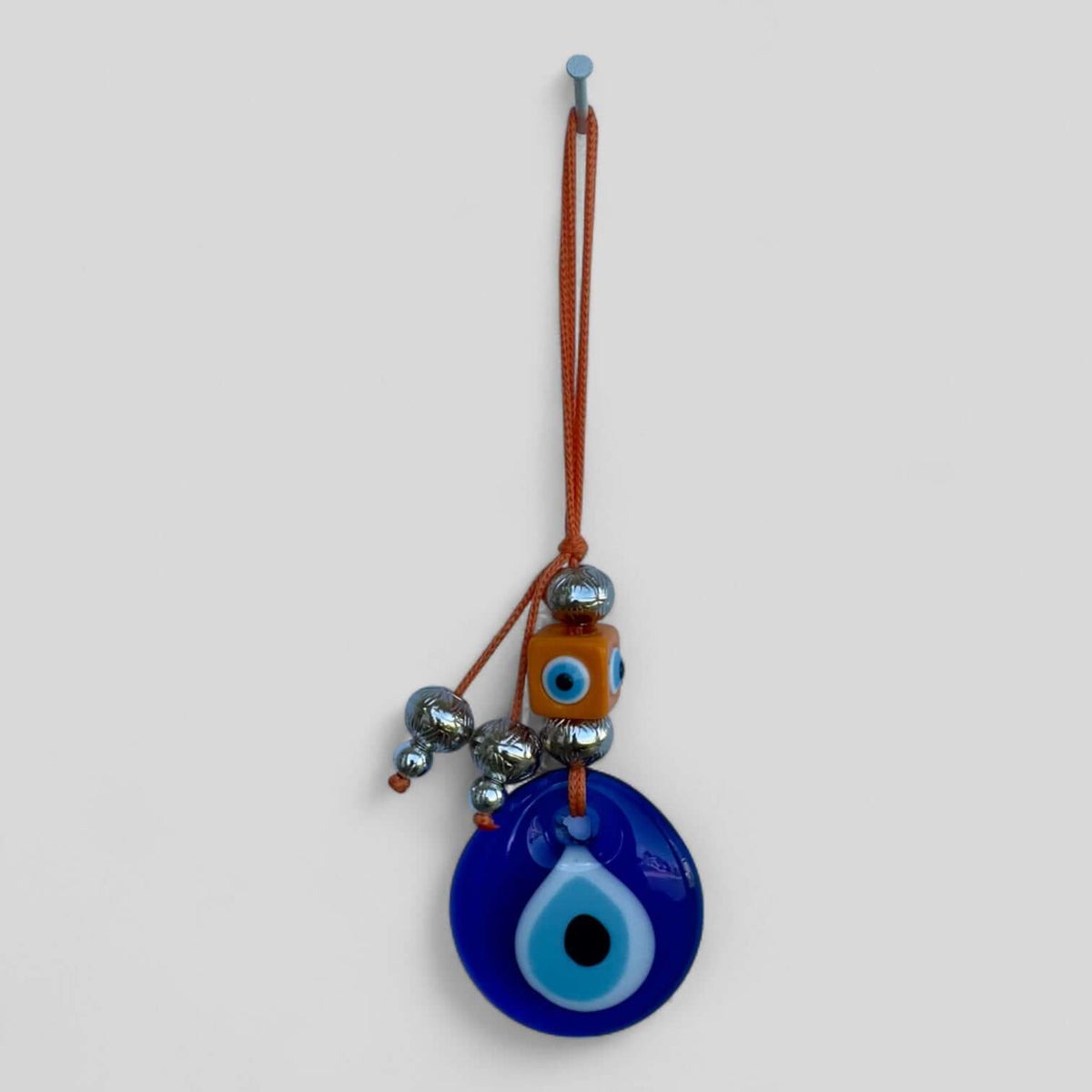 Handcrafted evil eye wall hanging in a modern boho style for entryways and bedrooms.