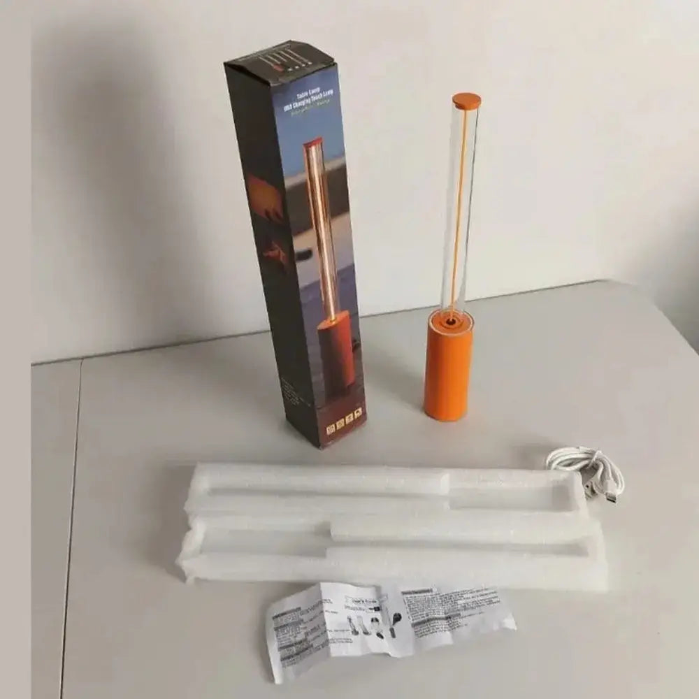 Rechargeable LED night light geometric bar in orange packaging with accessories and instructions on a table.