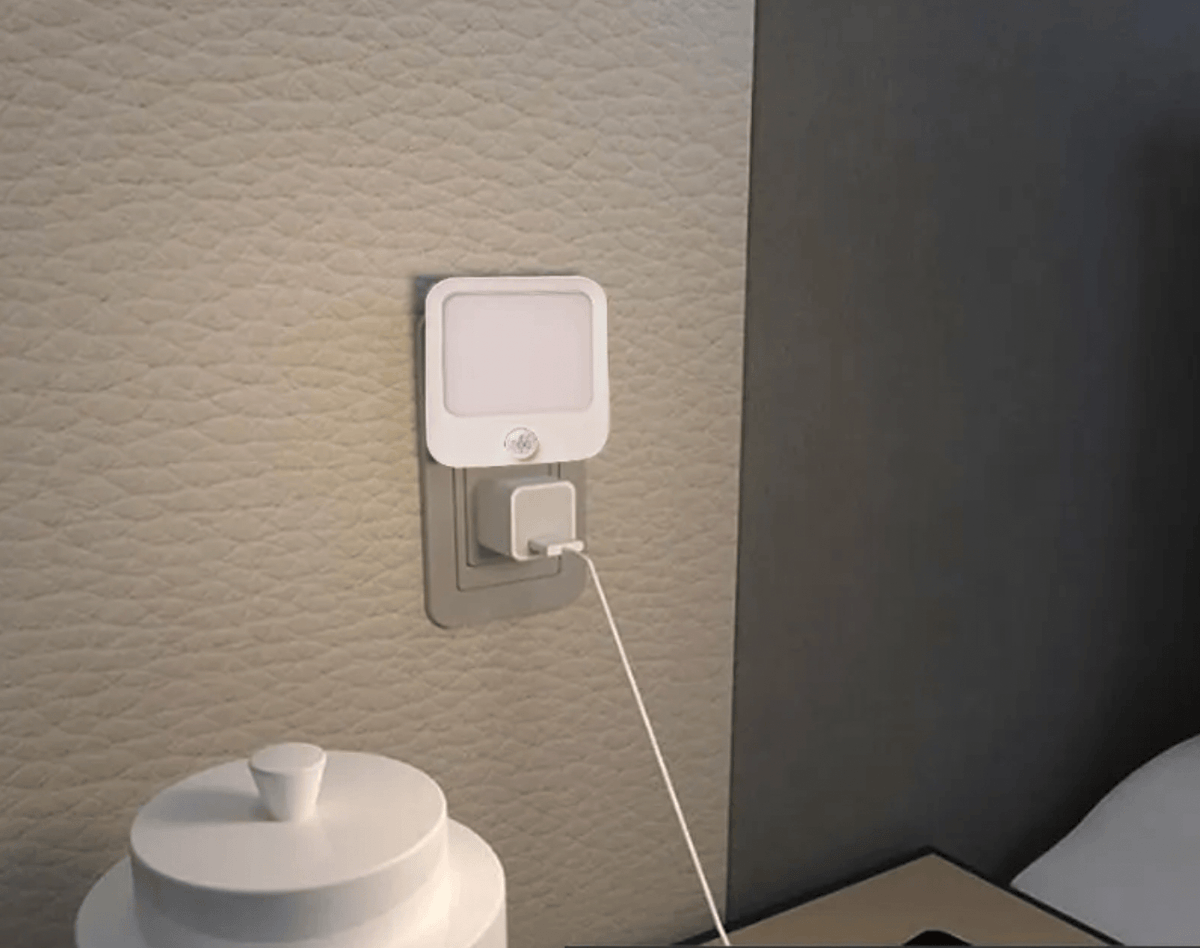 Red motion sensor night light with soft glow and 3 modes plugged into wall outlet