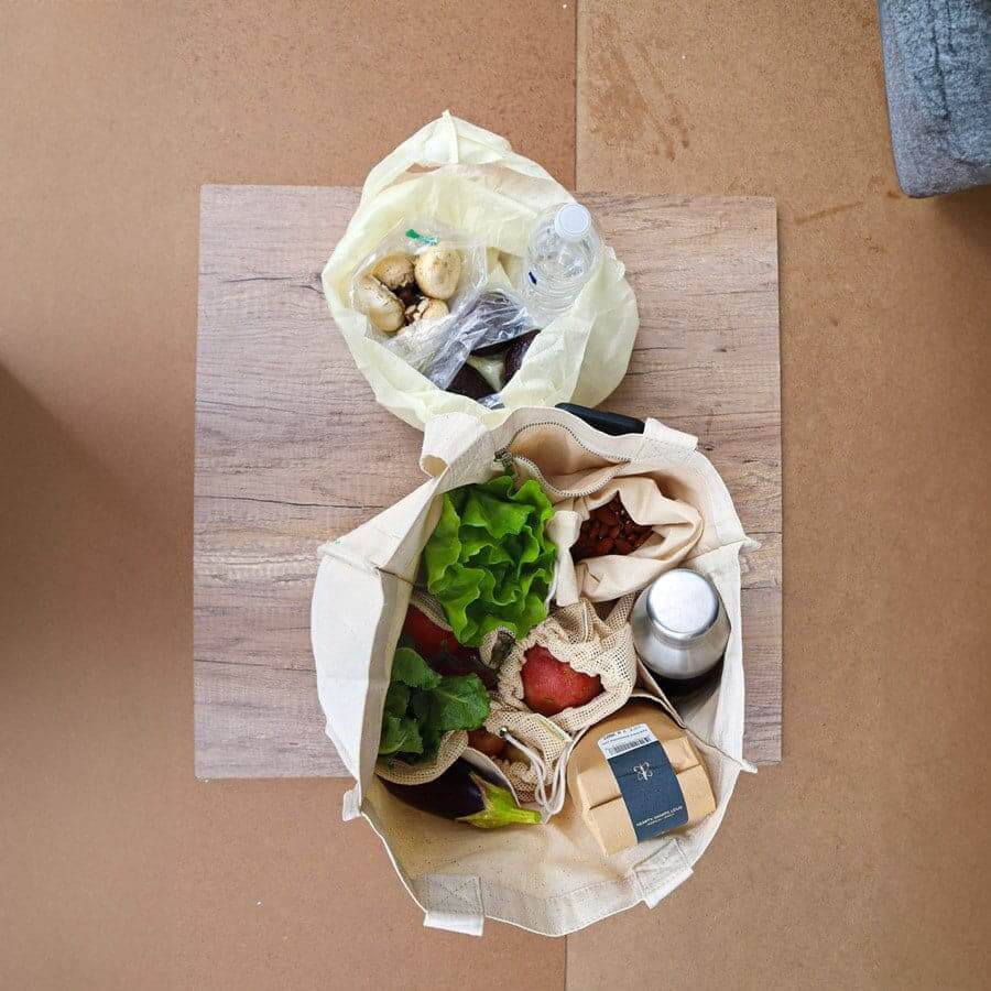 Reusable organic cotton produce bags set filled with fresh fruits and vegetables for sustainable shopping.