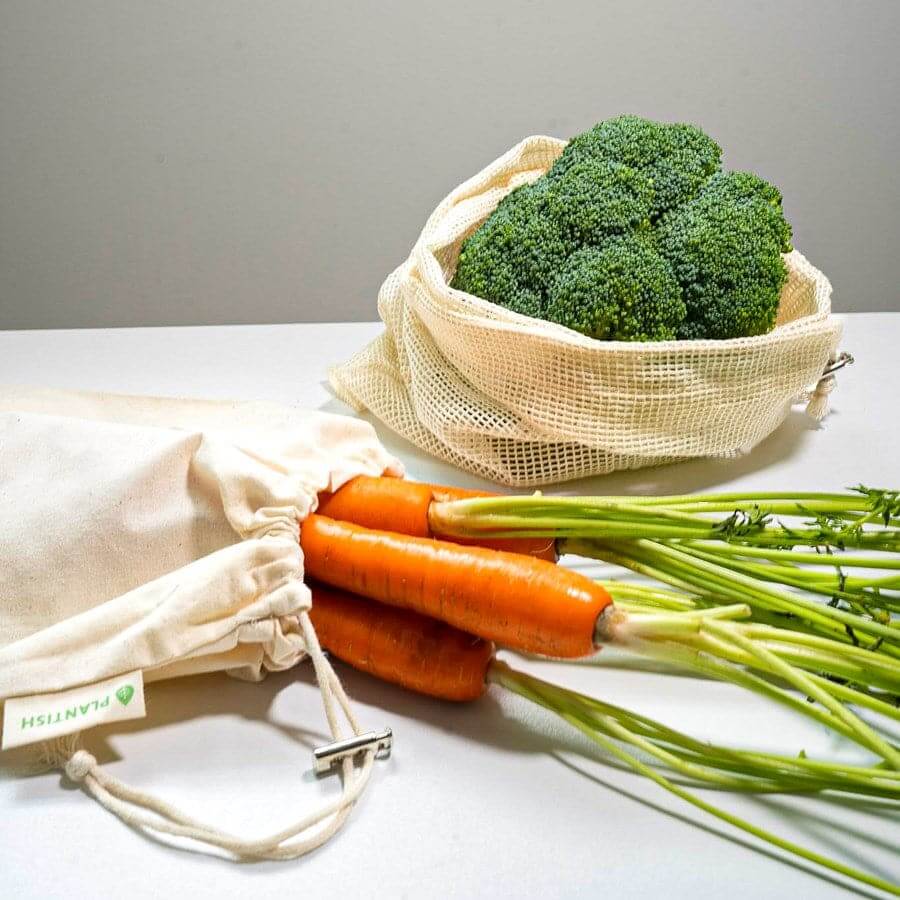 Organic cotton produce bags set displayed with fresh broccoli and carrots, promoting eco-friendly grocery shopping.