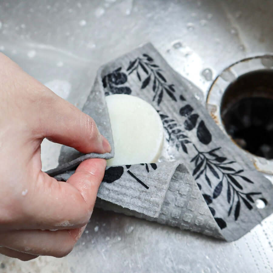 Swedish dishcloth being used to wipe down a kitchen counter.