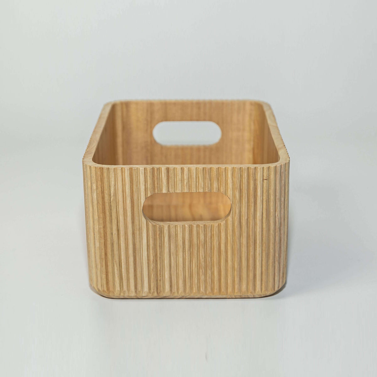 Wooden ribbed storage bin in natural paulownia wood with fluted exterior and handles