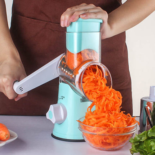 mandoline vegetable slicer with turquoise body slicing carrot into uniform shreds