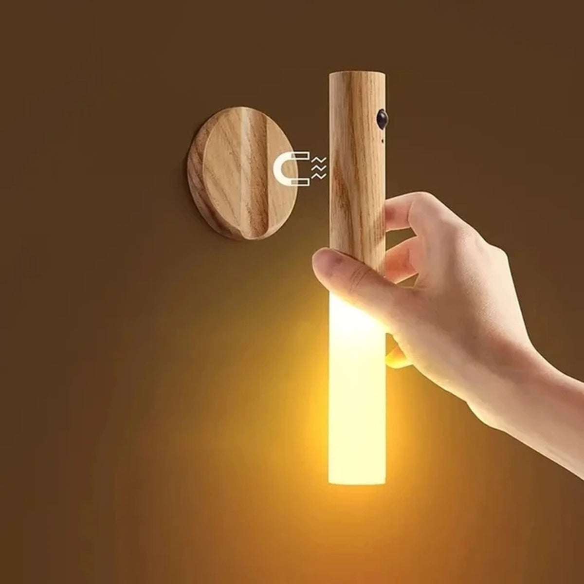 Rechargeable motion sensor night light with wood design held in hand, showing motion sensor feature and warm LED glow
