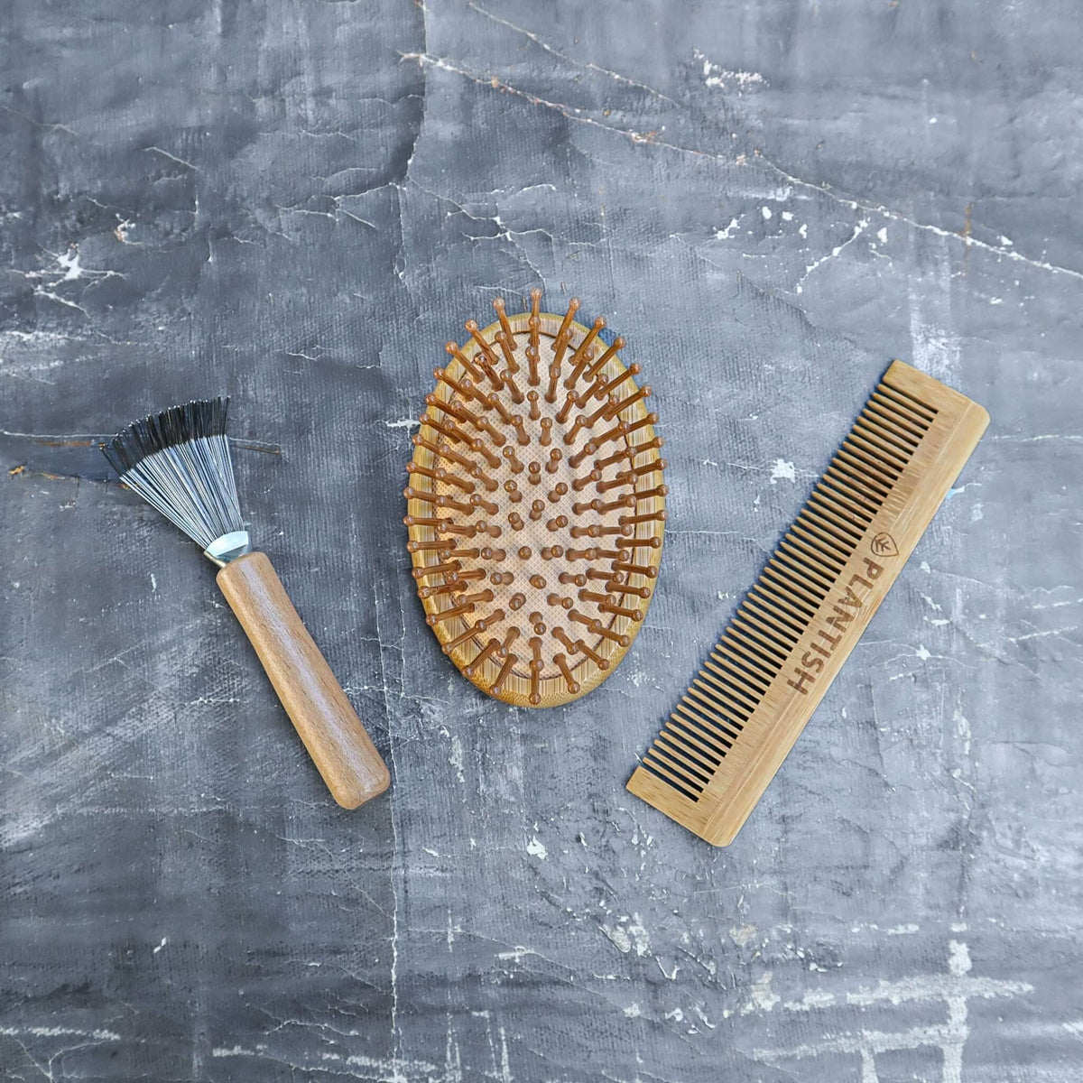 Bamboo hair brush and comb set displayed on a bathroom counter.