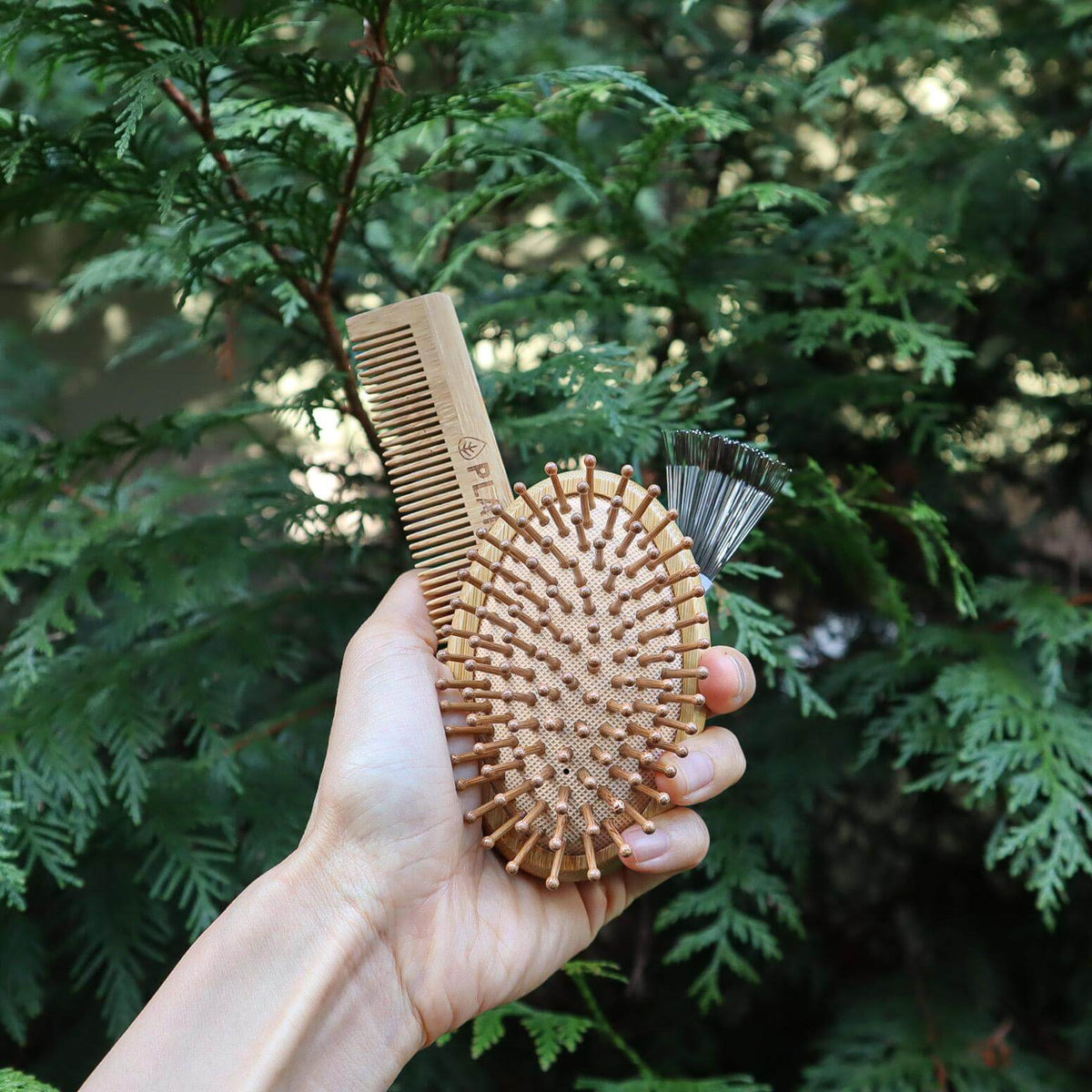 Bamboo hair brush and comb set packaged in a drawstring travel pouch.