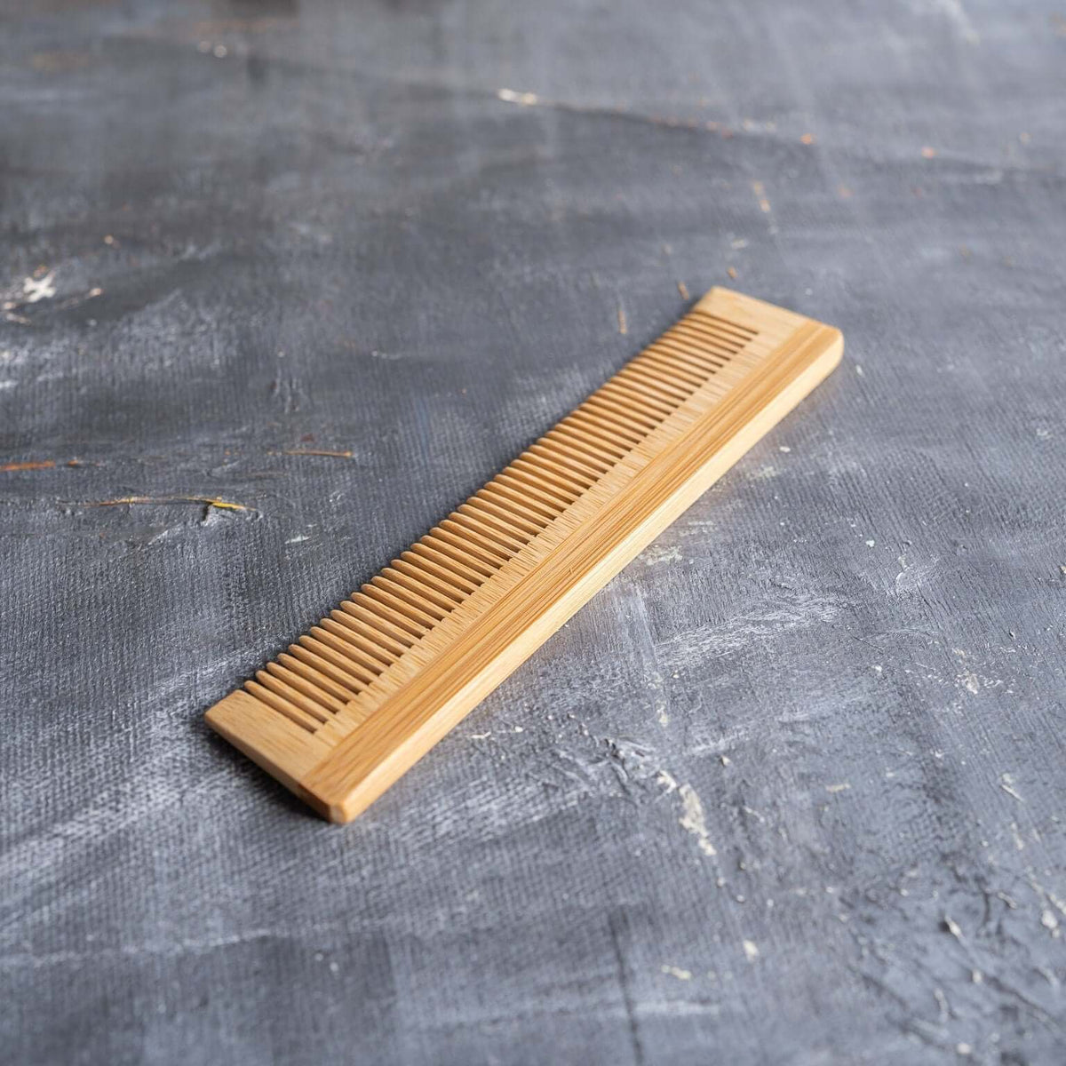 Bamboo hair brush and wide-tooth comb set laid out for travel hair care.