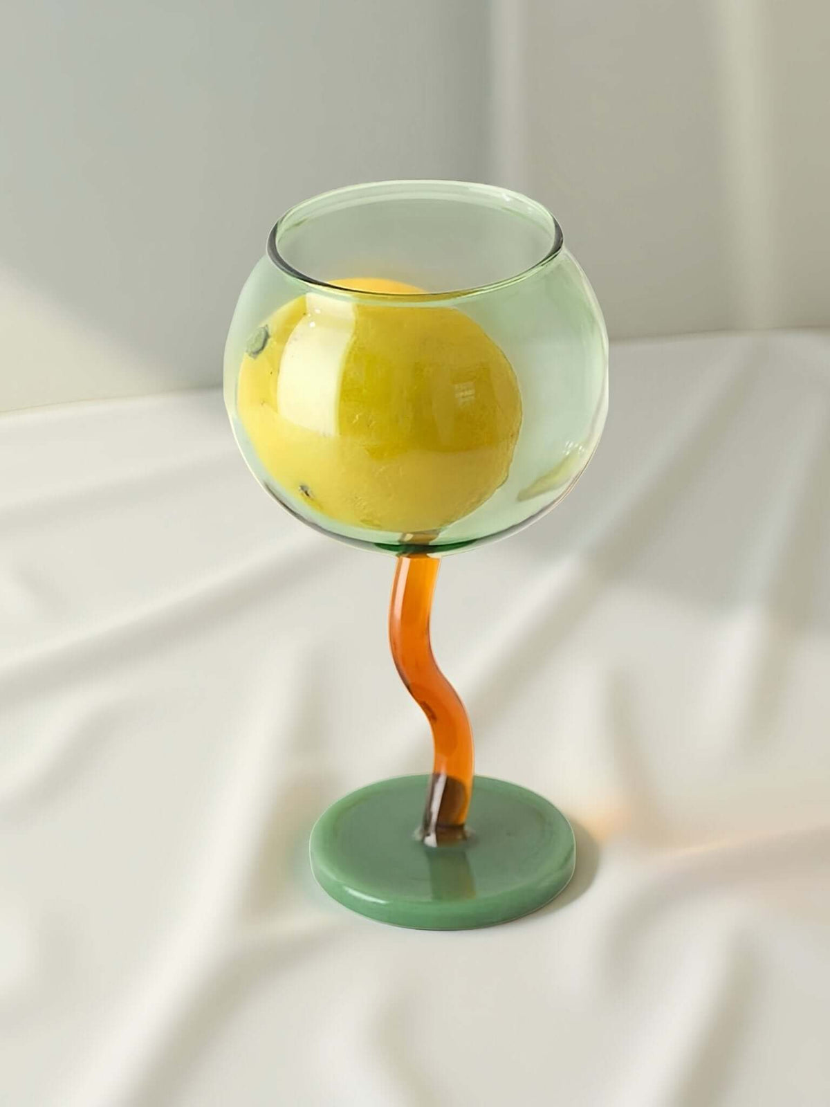 Handblown-style bubble wine glasses with colorful wavy stems, set for entertaining and table decor.
