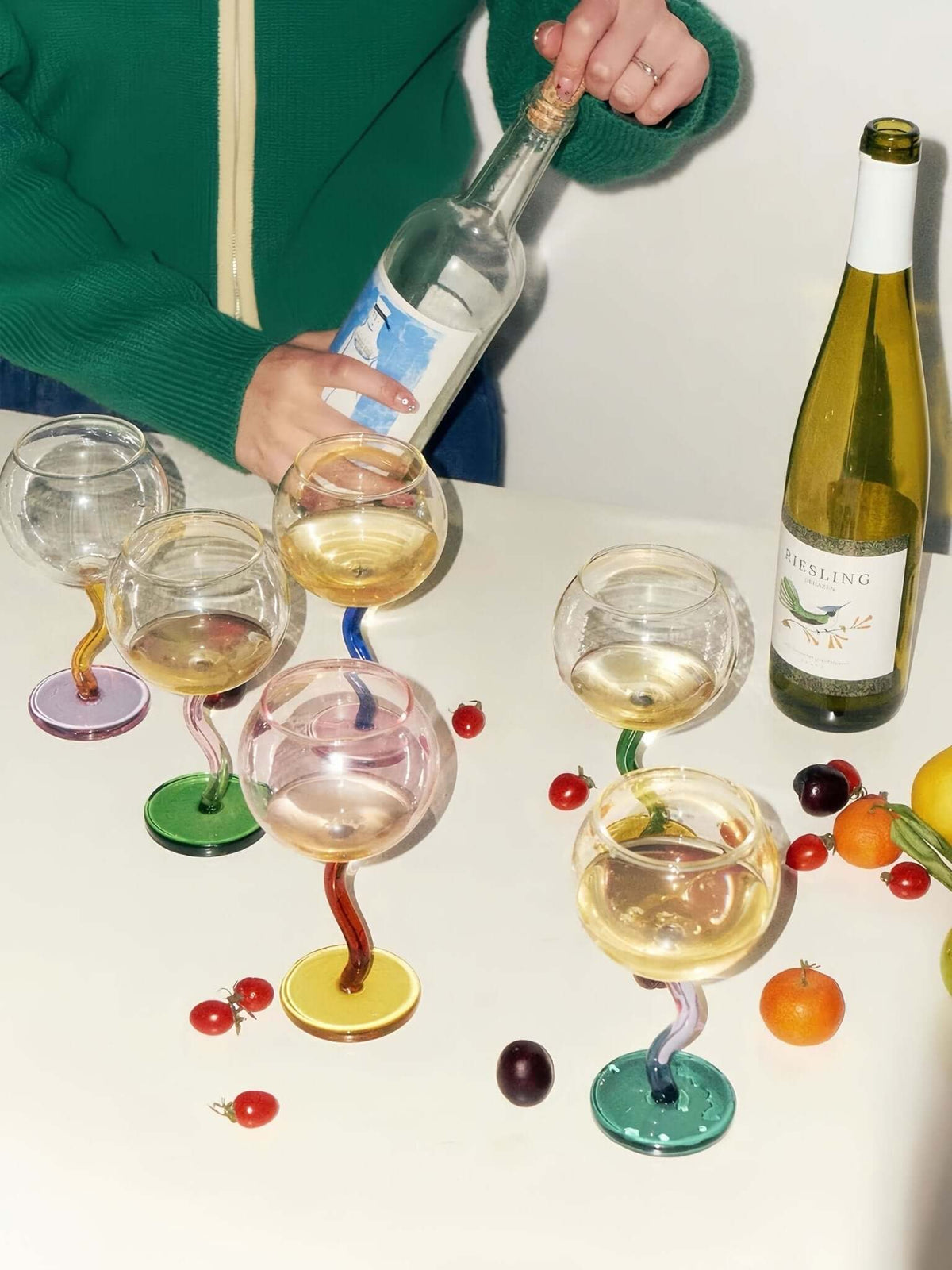 Handblown-style bubble wine glasses with colorful wavy stems, set for entertaining and table decor.