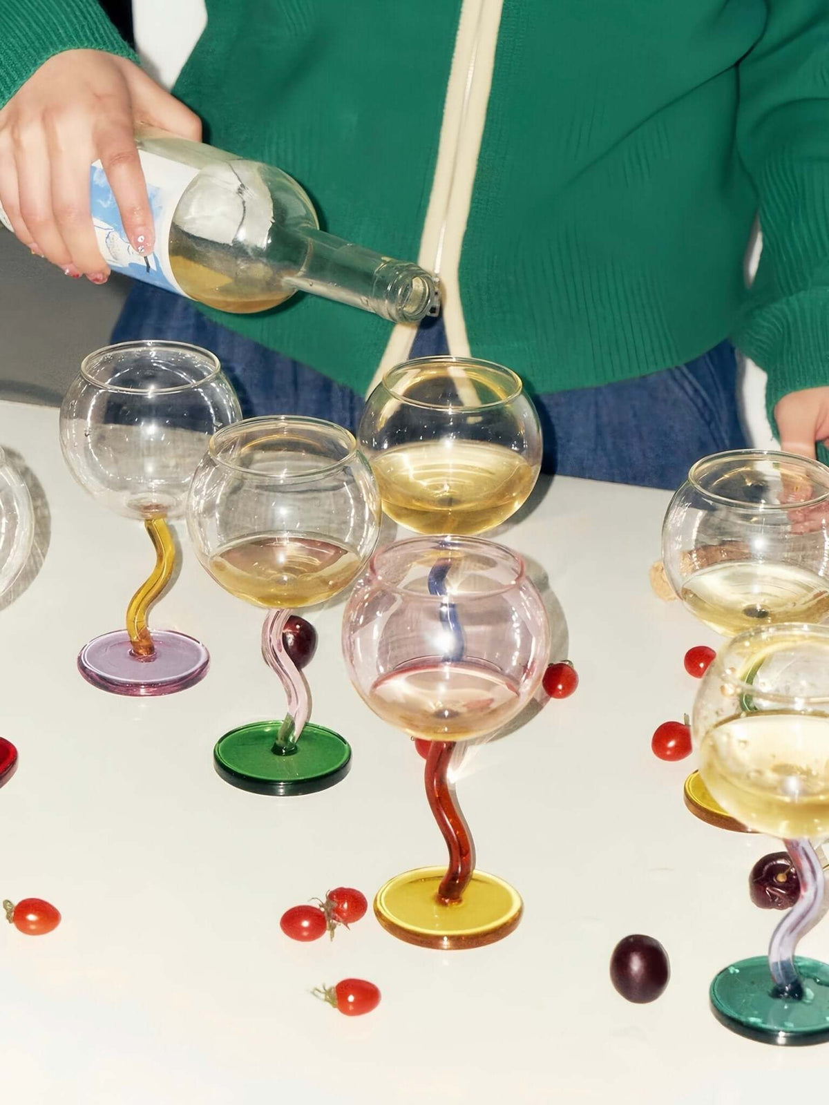 Bubble wine glass with a wavy stem shown from a side angle highlighting its handblown shape.