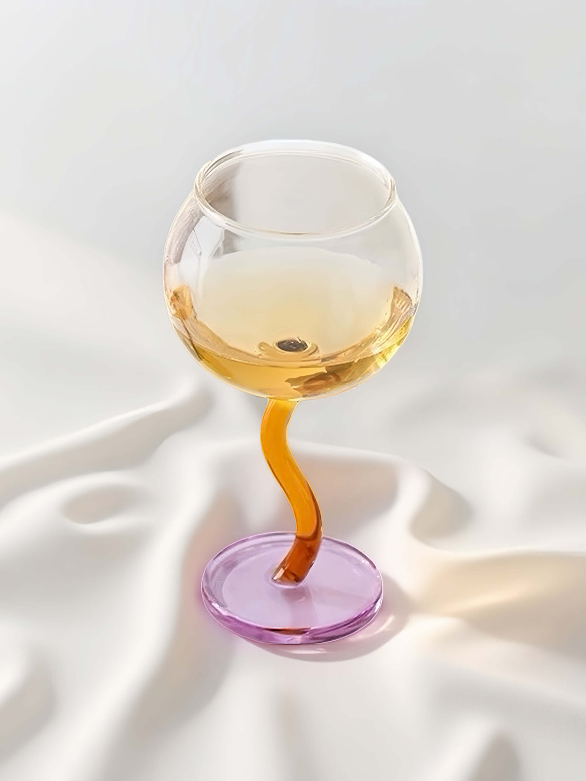 Handblown-style bubble wine glasses with colorful wavy stems, set for entertaining and table decor.