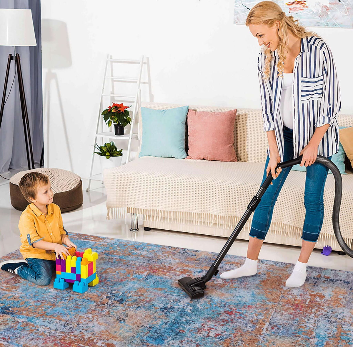 washable stain-resistant area rug with abstract design being vacuumed clean by woman while child plays