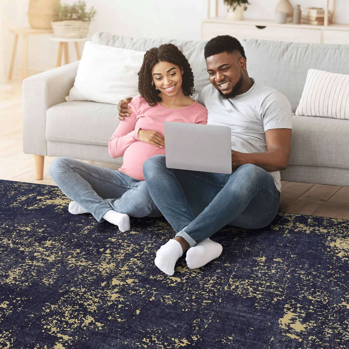 Luna Select Market washable area rug with a black abstract pattern in a cozy living room with a couple using a laptop.