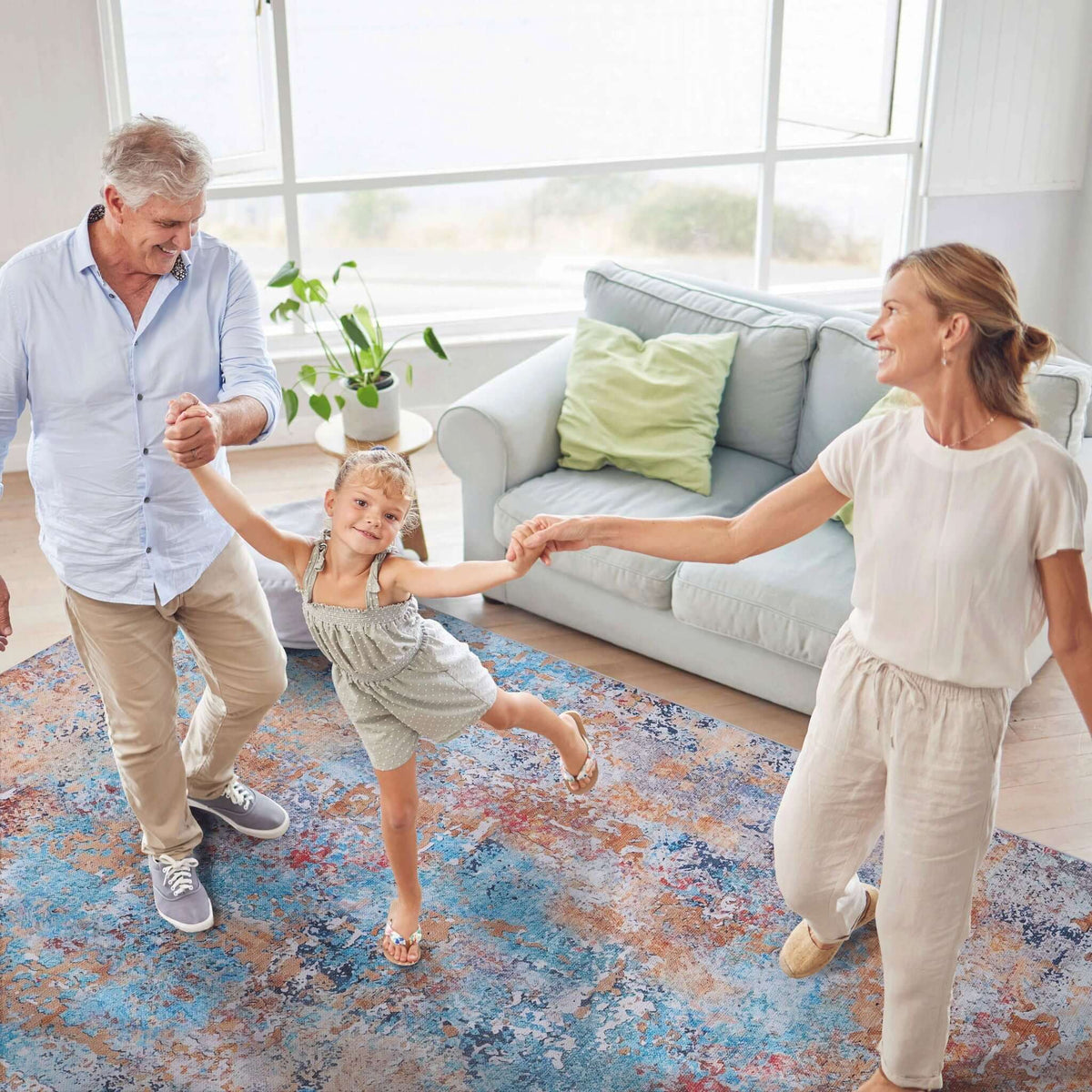 washable stain-resistant area rug with abstract design in blue, gray and rust tones in family living room