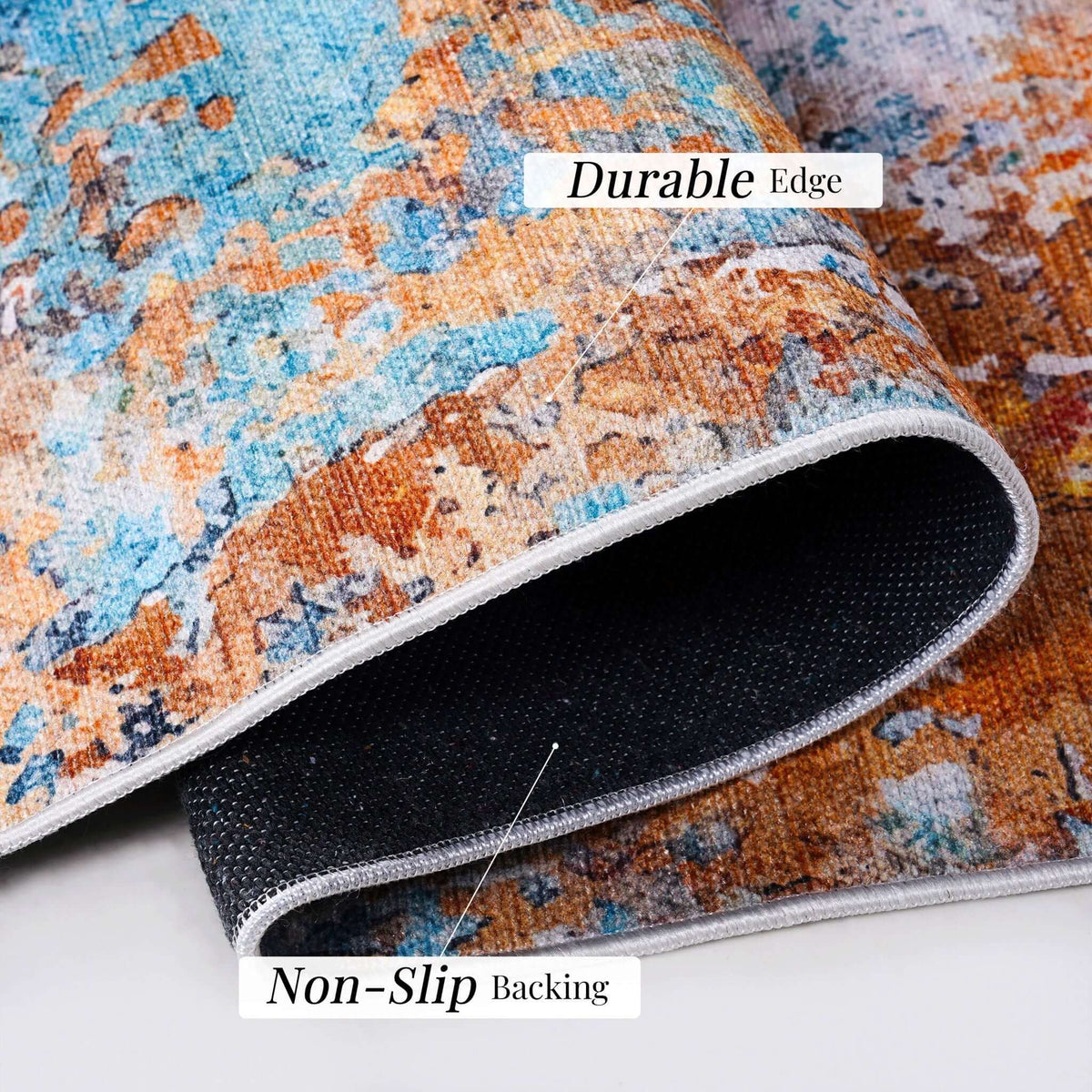 washable stain-resistant area rug with low-pile abstract design in blue, orange and gray showing durable edge and non-slip backing