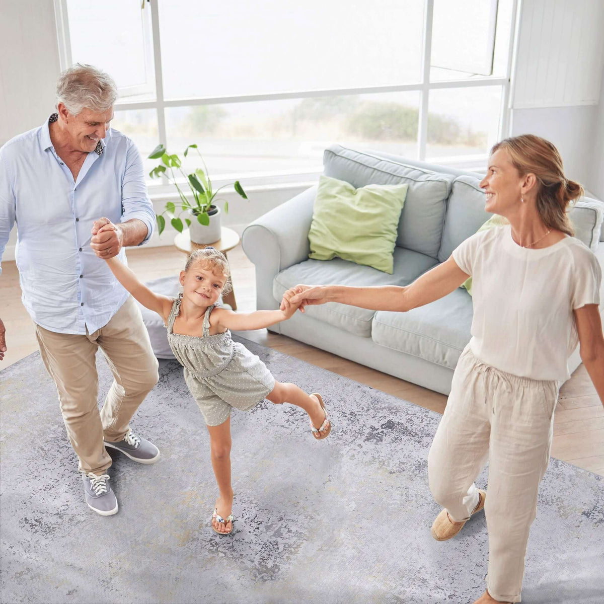 washable stain-resistant area rug in light blue with family playing in living room