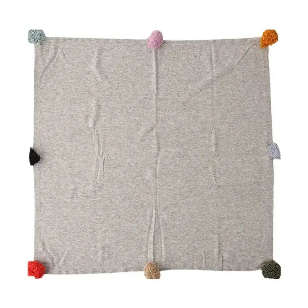 Luxury cashmere throw blanket draped over the arm of a reading chair