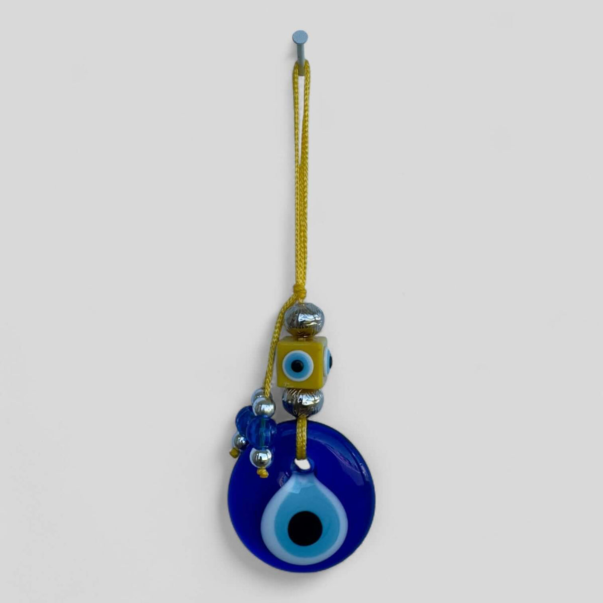 Handcrafted evil eye wall hanging in a modern boho style for entryways and bedrooms.