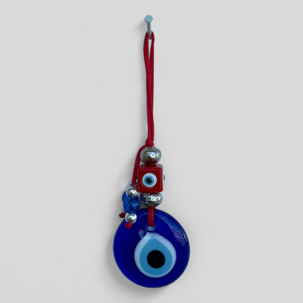 Modern boho evil eye wall hanging shown in an assortment of color options.