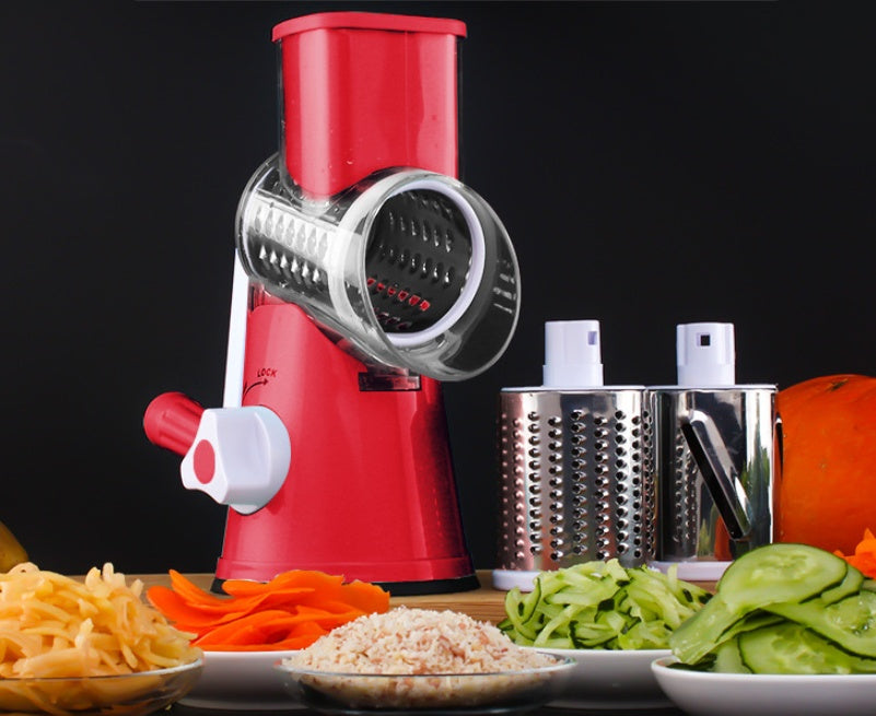 Mandoline vegetable slicer in red with assorted sliced vegetables and cheese on a kitchen counter.