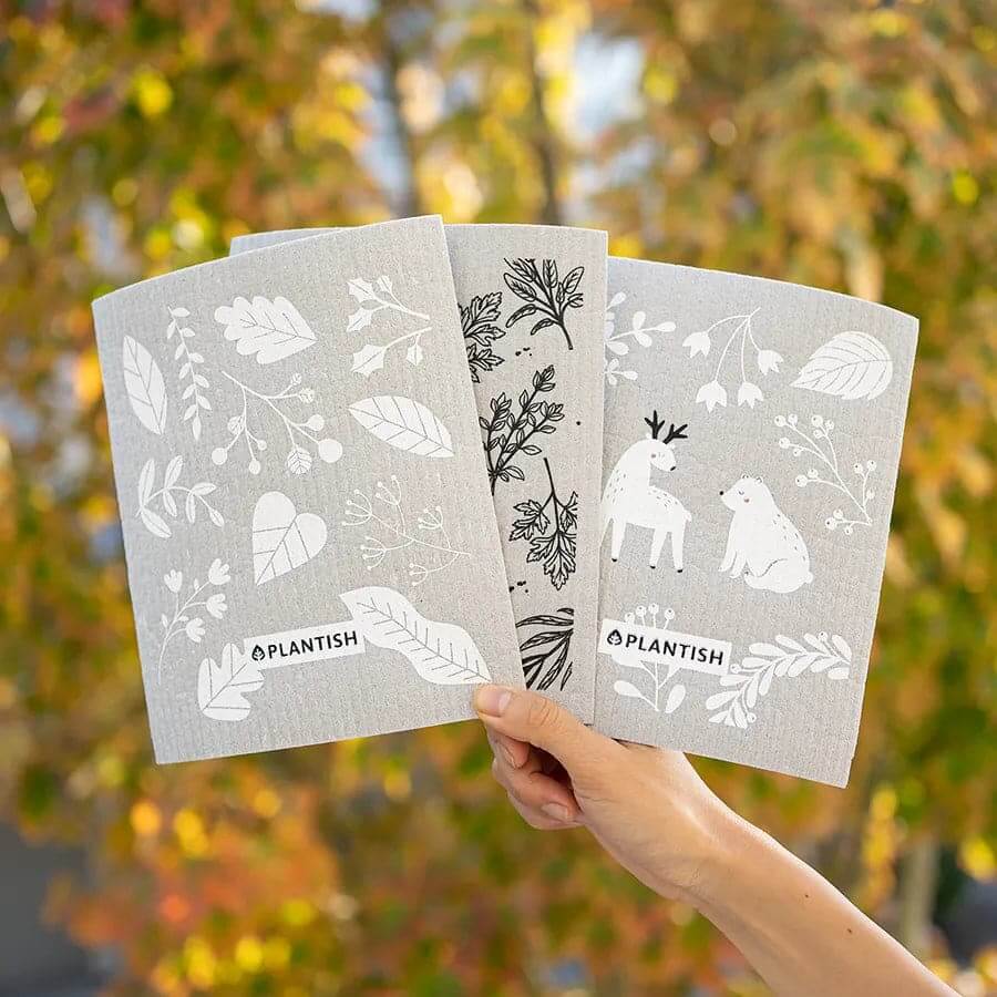 Swedish sponge cloths fanned out showing the Into the Woods forest print.