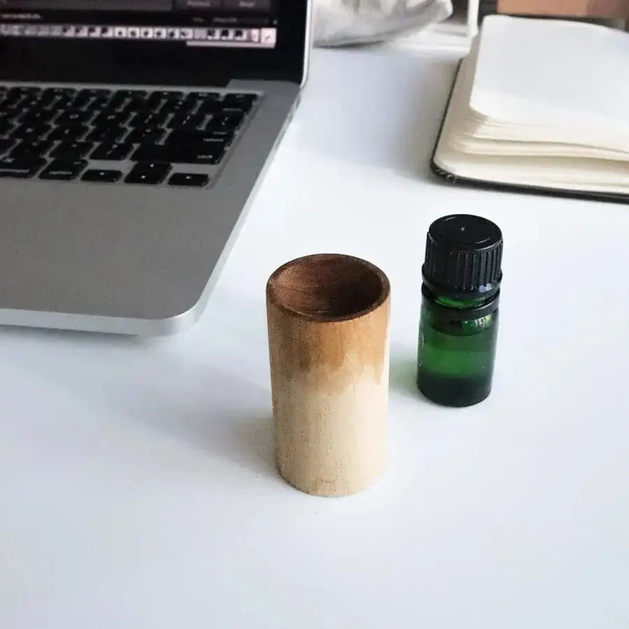 Portable essential oil diffuser with a natural wooden design for aromatherapy on the go.
