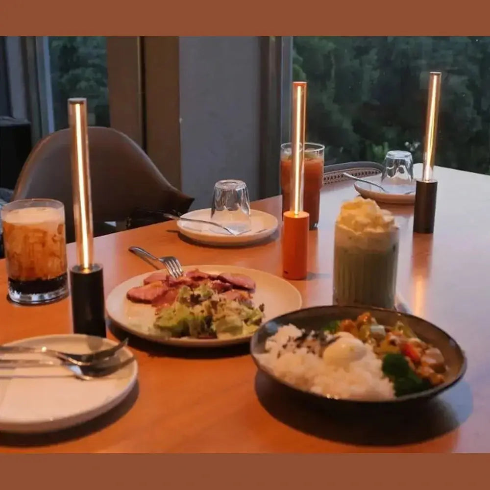 Rechargeable LED night light geometric bar illuminating a dining table with food and drinks.