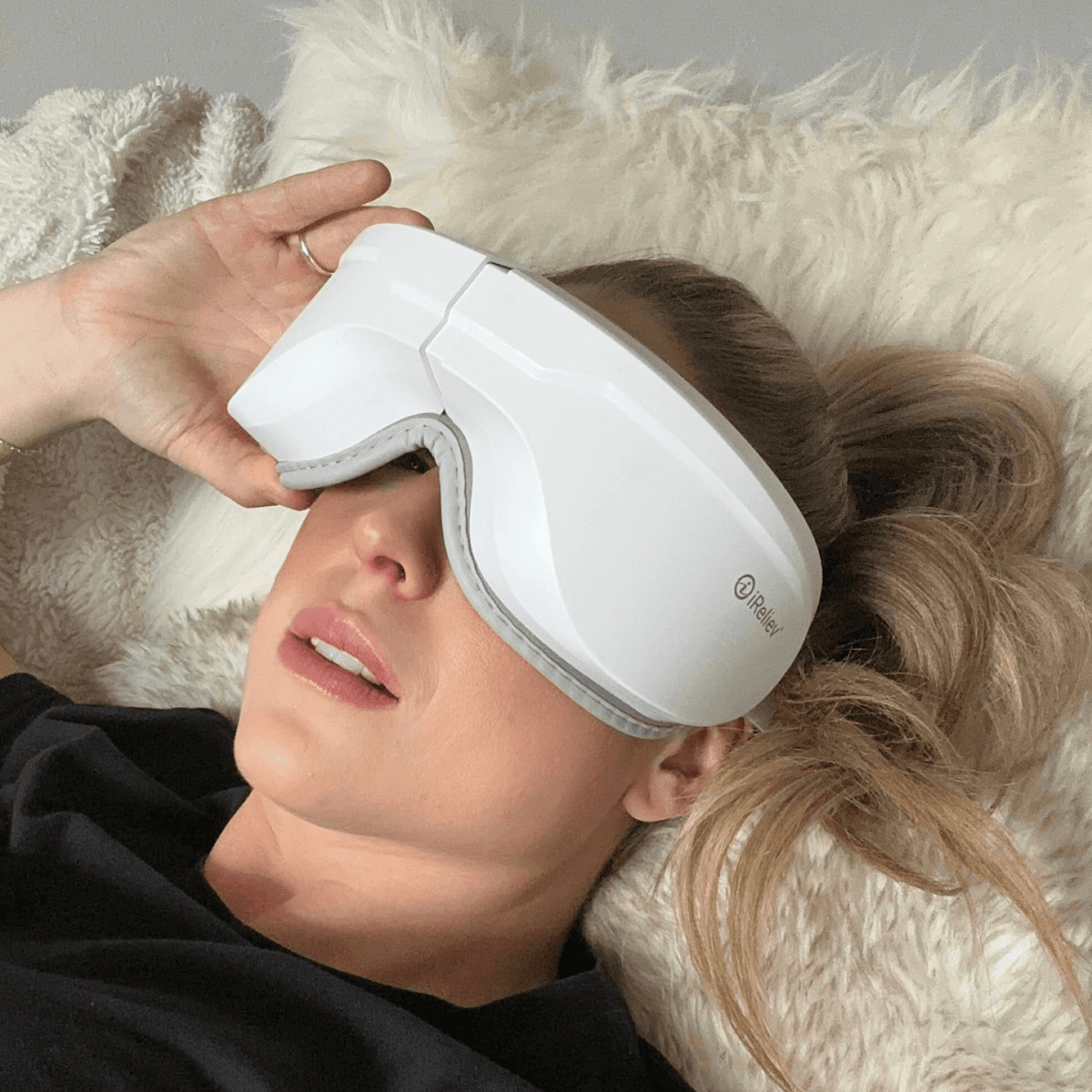 Woman wearing white Relaxable™ heated eye massager with gentle warmth and vibration for eye relaxation