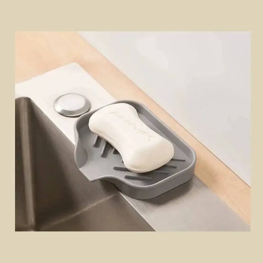Silicone auto-draining sponge holder on a kitchen sink, designed for effective drainage and air circulation.