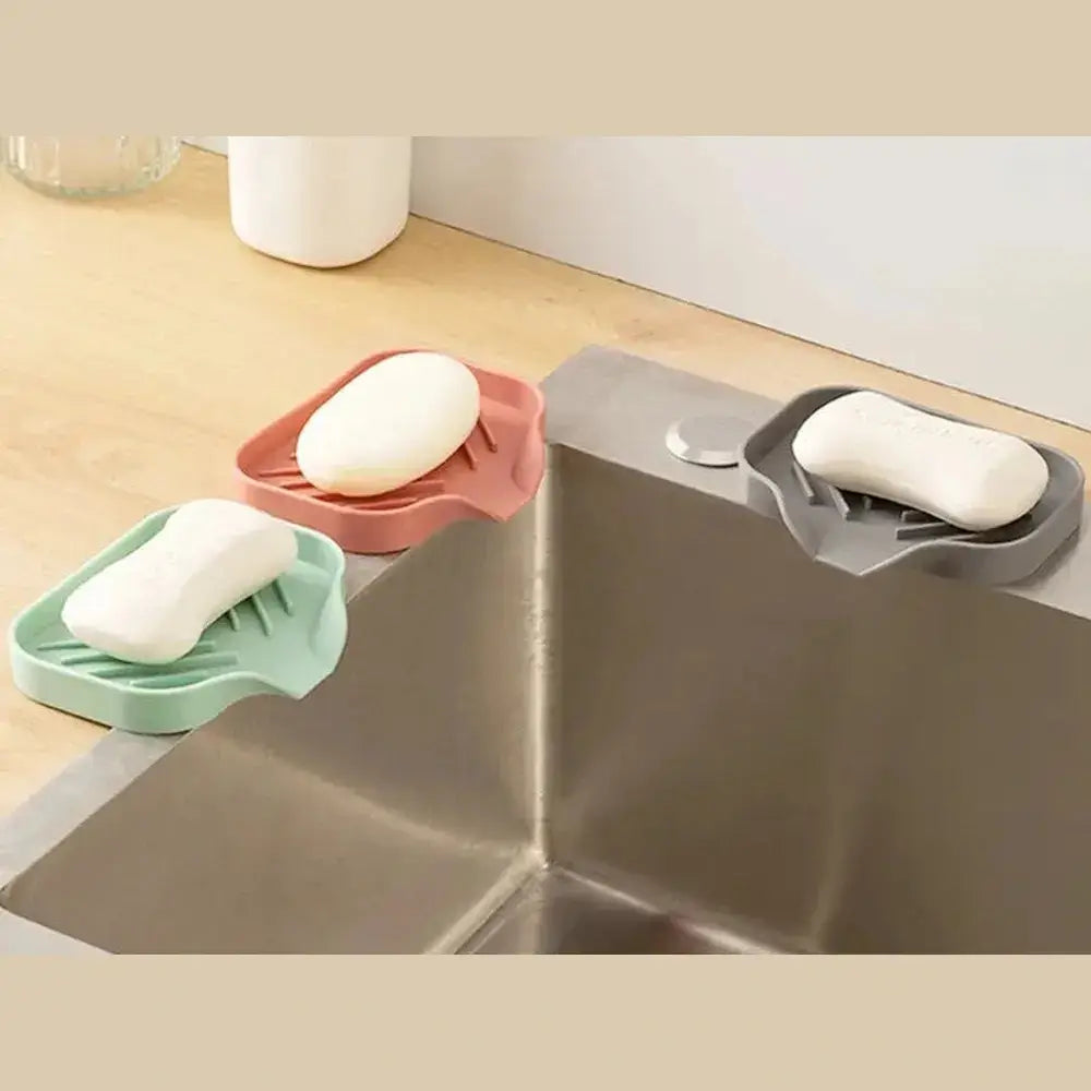 Silicone auto-draining sponge holder in various colors, lifting sponges from the sink for better drainage and airflow.