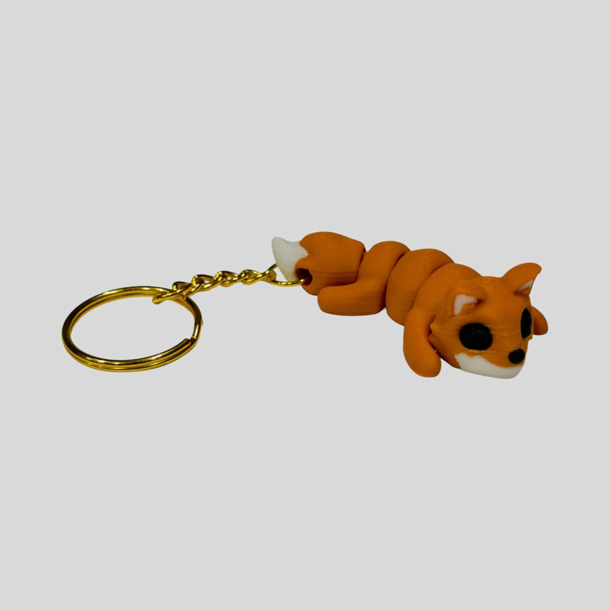 3D printed sleepy fox keychain on a lightweight metal ring.