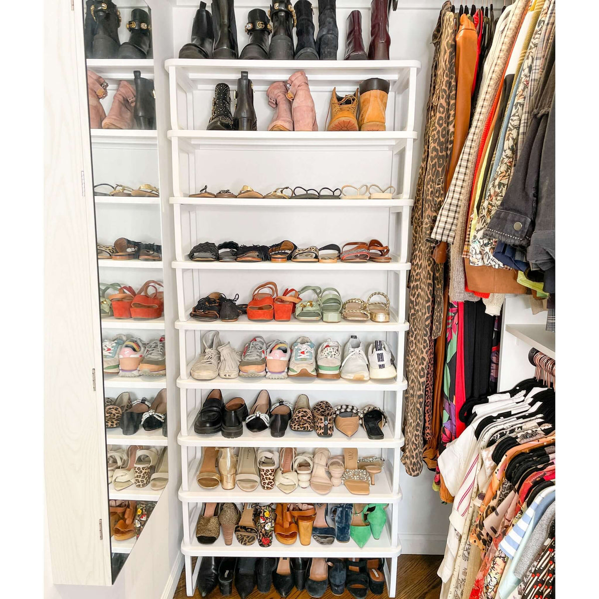 stackable white wooden shoe shelf displaying organized boots, heels, sandals, and sneakers