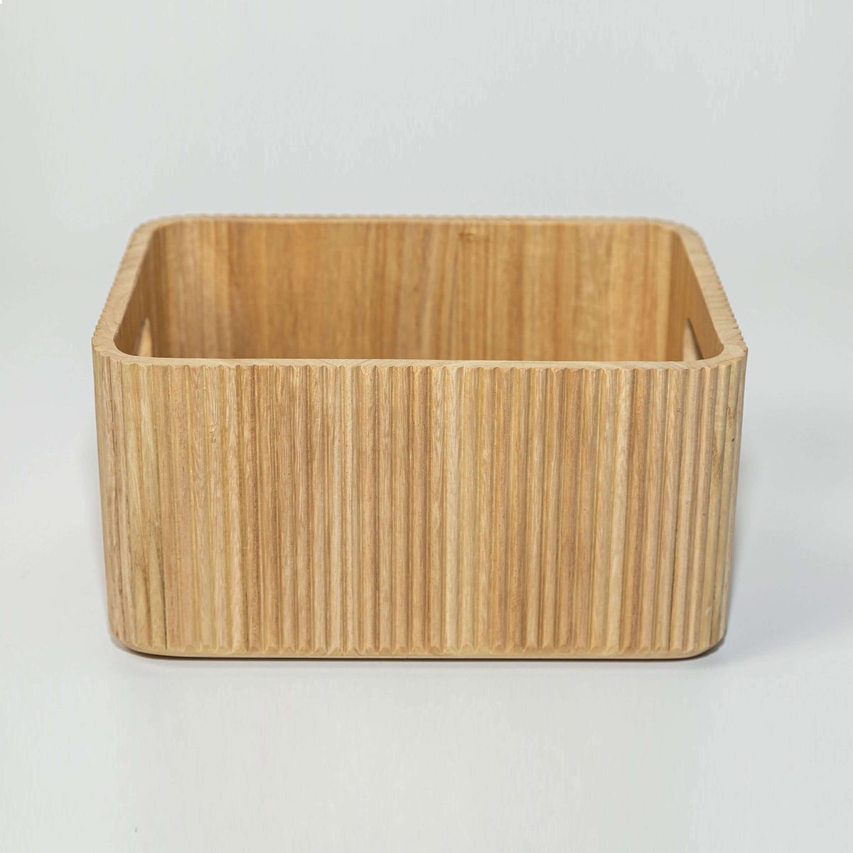 wooden ribbed storage bin in natural paulownia wood with fluted exterior and handles