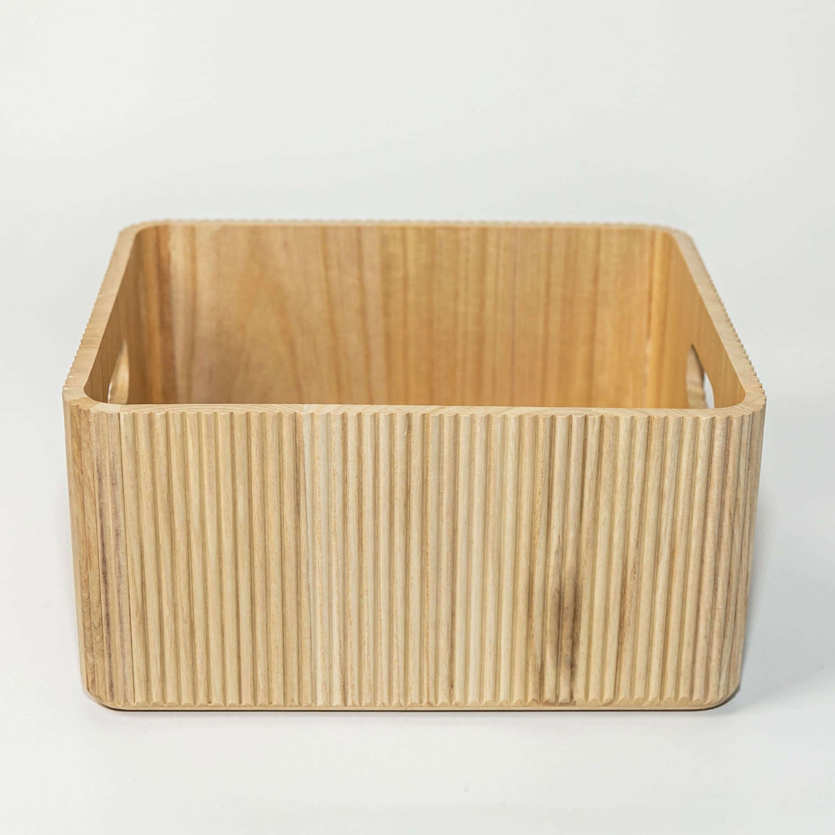 wooden ribbed storage bin in natural paulownia wood with fluted exterior and handles